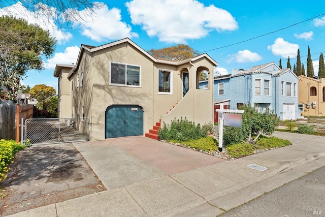 multi unit property with stucco siding, driveway, a gate, an attached garage, and stairs