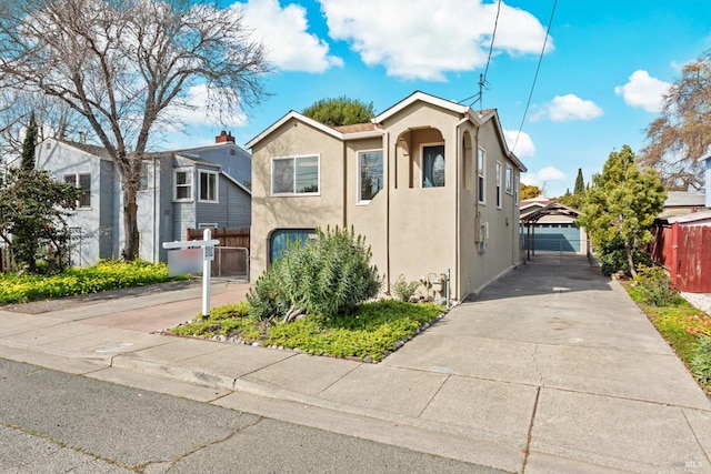 view of front of house featuring a gate, stucco siding, a detached garage, and fence