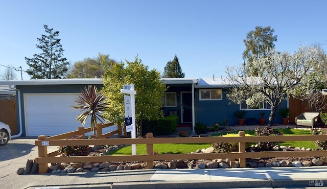 view of front of property featuring a fenced front yard and a garage