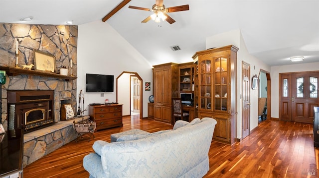 living area featuring hardwood / wood-style floors, visible vents, a fireplace, ceiling fan, and beamed ceiling