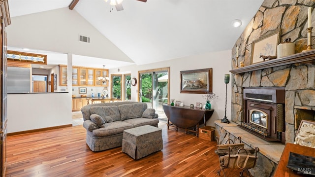 living area with visible vents, high vaulted ceiling, ceiling fan, and wood finished floors