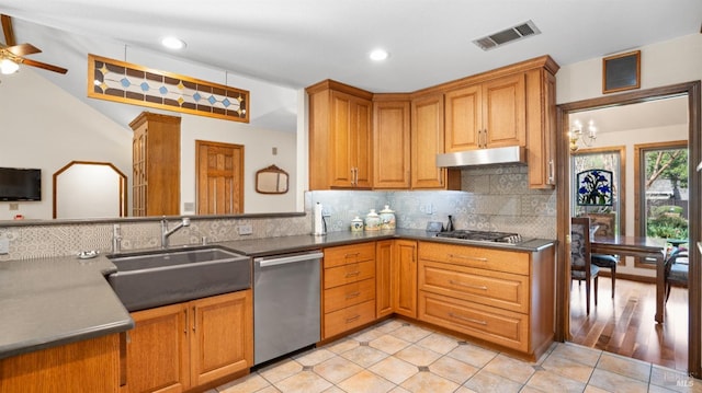 kitchen with visible vents, under cabinet range hood, decorative backsplash, appliances with stainless steel finishes, and a sink