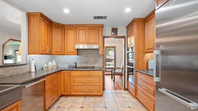 kitchen with light tile patterned floors, visible vents, backsplash, and appliances with stainless steel finishes