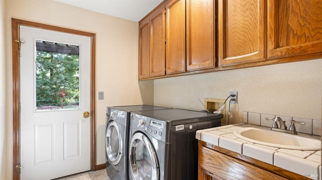 laundry room featuring separate washer and dryer, cabinet space, and a sink