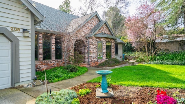 view of property exterior with a lawn, roof with shingles, and brick siding