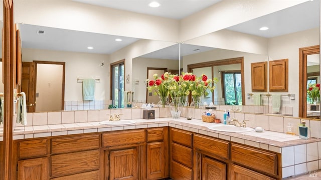 bathroom with a sink, recessed lighting, and double vanity