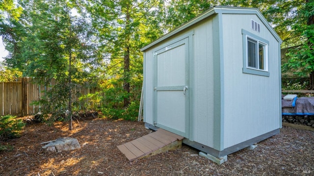 view of shed featuring fence