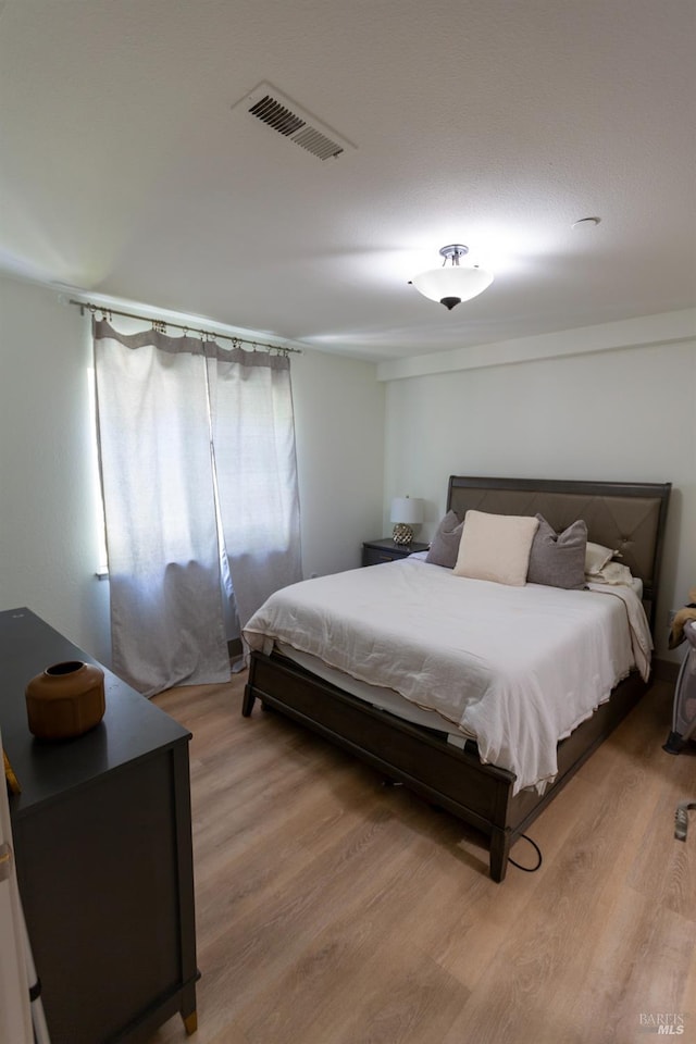 bedroom with visible vents and light wood-style floors