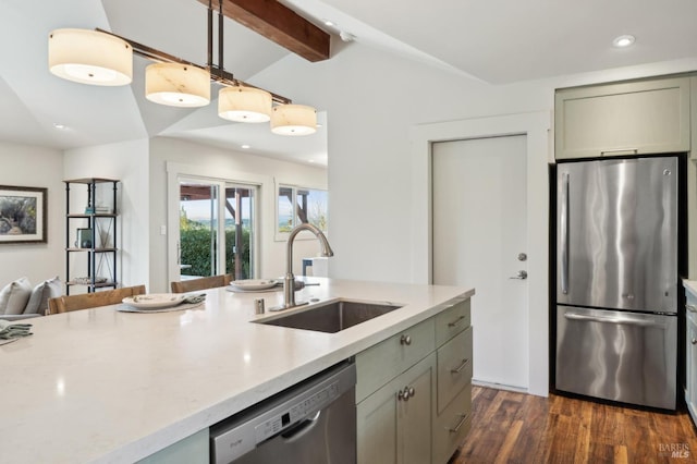 kitchen featuring a sink, vaulted ceiling with beams, pendant lighting, appliances with stainless steel finishes, and dark wood-style flooring