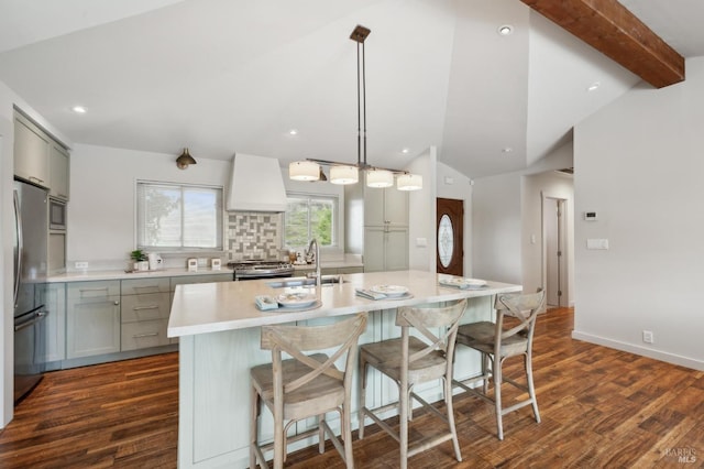 kitchen with vaulted ceiling with beams, gray cabinets, appliances with stainless steel finishes, custom exhaust hood, and a sink