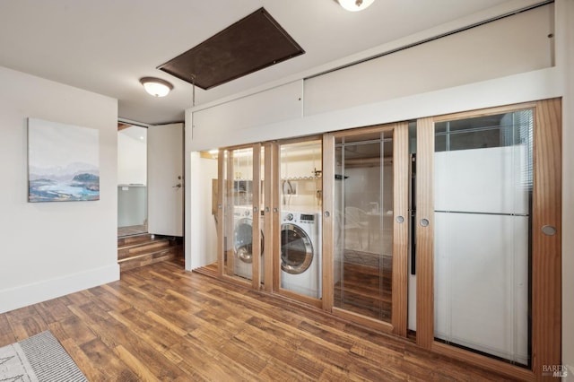 interior space with baseboards, attic access, and wood finished floors