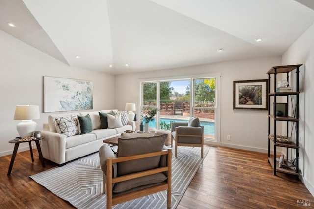 living area featuring vaulted ceiling, dark wood-style floors, and baseboards