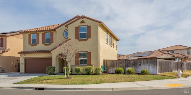 mediterranean / spanish-style house featuring a front yard, fence, driveway, stucco siding, and a tile roof