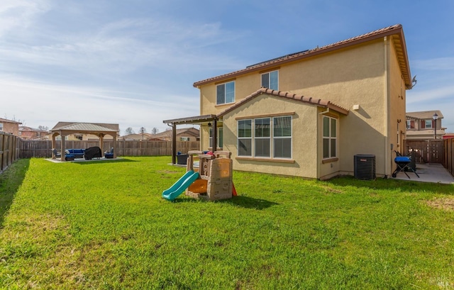 rear view of house with a playground, stucco siding, a fenced backyard, a patio area, and a pergola