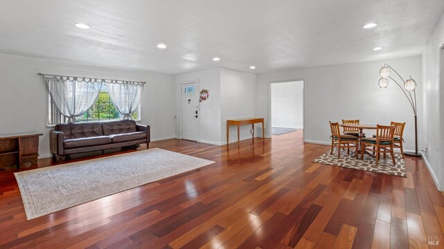 living area with recessed lighting, wood finished floors, and baseboards