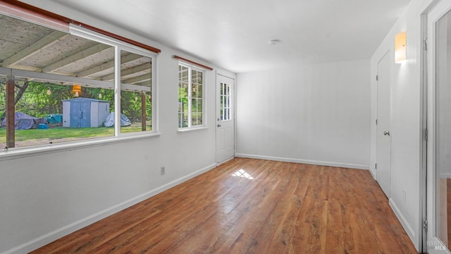 unfurnished room featuring hardwood / wood-style flooring and baseboards