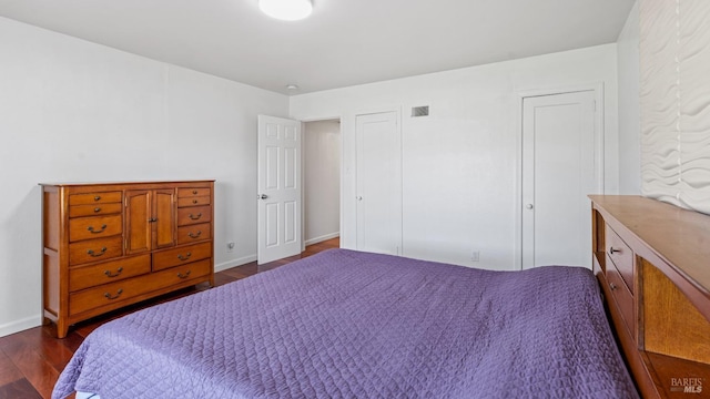 bedroom featuring dark wood-style floors, visible vents, and baseboards