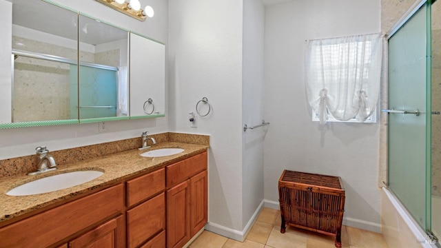 full bathroom with tile patterned floors, double vanity, baseboards, and a sink