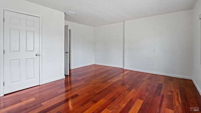 unfurnished room with baseboards and wood finished floors