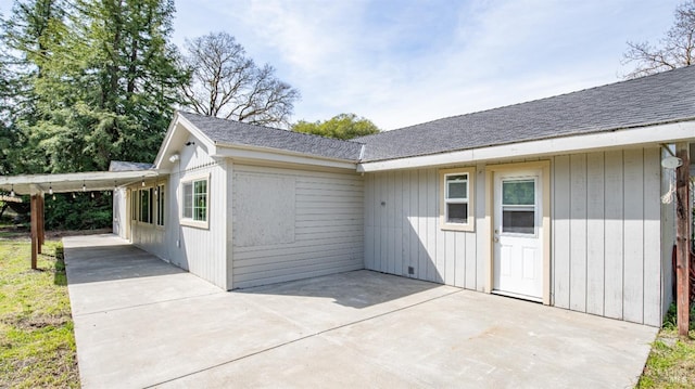 exterior space with a patio and roof with shingles