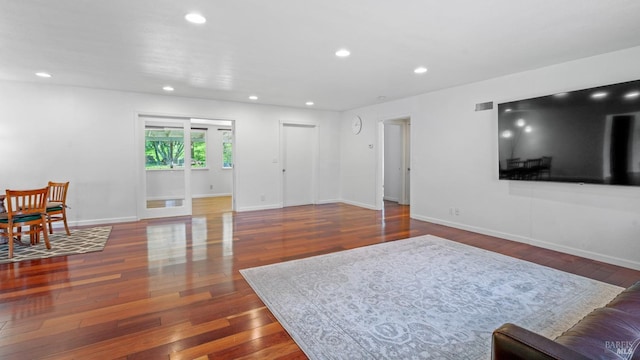 living area with hardwood / wood-style floors, visible vents, recessed lighting, and baseboards