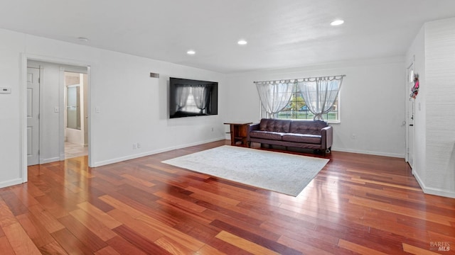 living area featuring recessed lighting, visible vents, baseboards, and wood finished floors