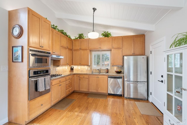 kitchen featuring light wood-style flooring, vaulted ceiling with beams, under cabinet range hood, appliances with stainless steel finishes, and backsplash