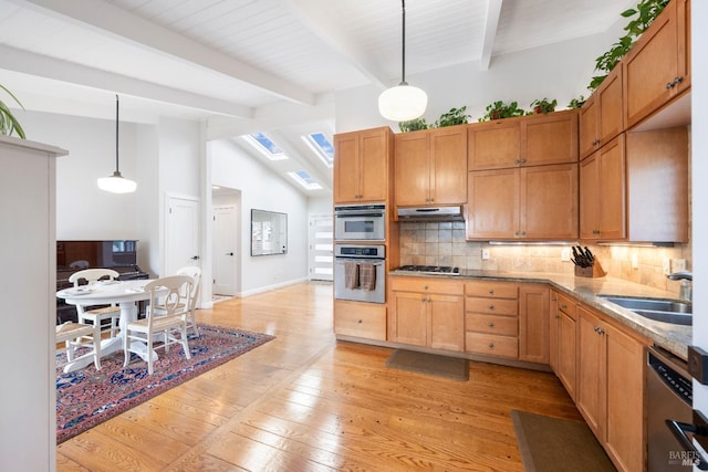 kitchen with light wood finished floors, lofted ceiling with beams, a sink, stainless steel appliances, and tasteful backsplash