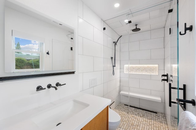 bathroom with vanity, a shower stall, and toilet