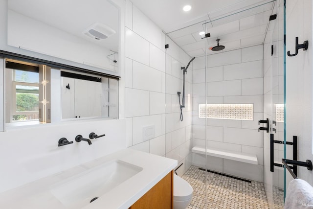 bathroom with toilet, a stall shower, and vanity