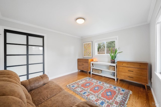 sitting room featuring crown molding, wood finished floors, and baseboards