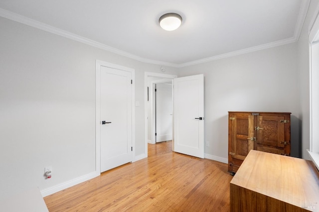 unfurnished bedroom with light wood-style flooring, baseboards, and ornamental molding