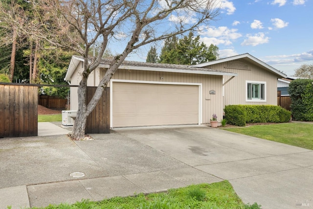 ranch-style house with an attached garage, fence, and driveway