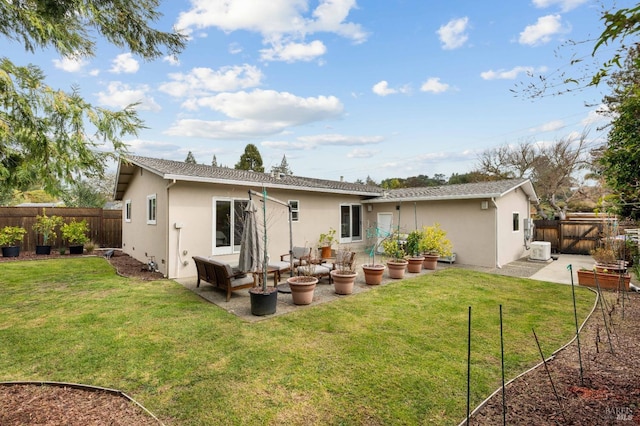 back of property with a yard, a patio area, and stucco siding