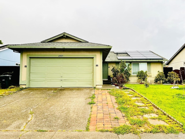 single story home with a garage, roof mounted solar panels, a front lawn, and driveway