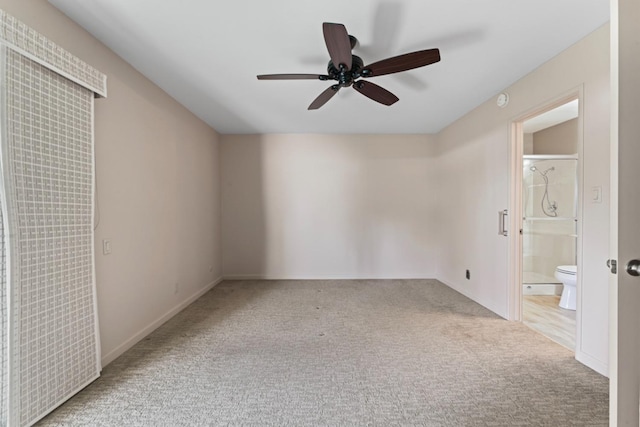 unfurnished bedroom with baseboards, ensuite bathroom, ceiling fan, and carpet flooring