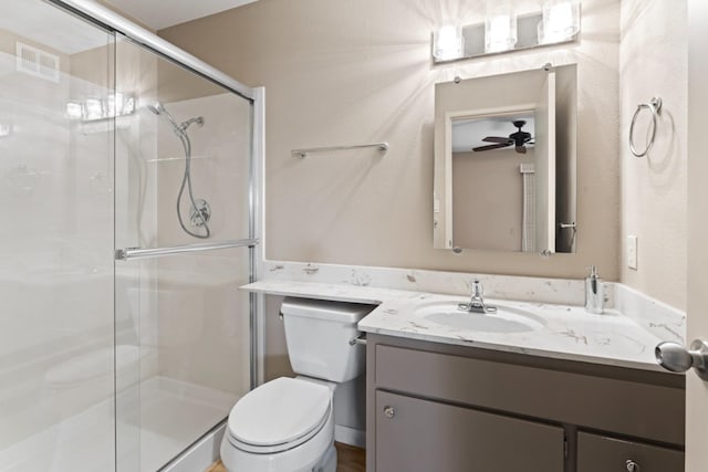 bathroom with visible vents, a stall shower, toilet, and vanity