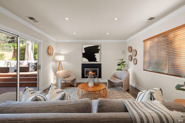 living room with a glass covered fireplace, wood finished floors, and ornamental molding