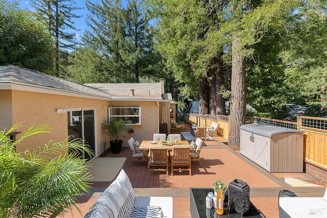 view of patio featuring a wooden deck, outdoor dining area, and fence