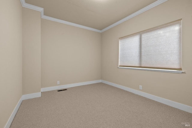 carpeted spare room with visible vents, baseboards, and ornamental molding