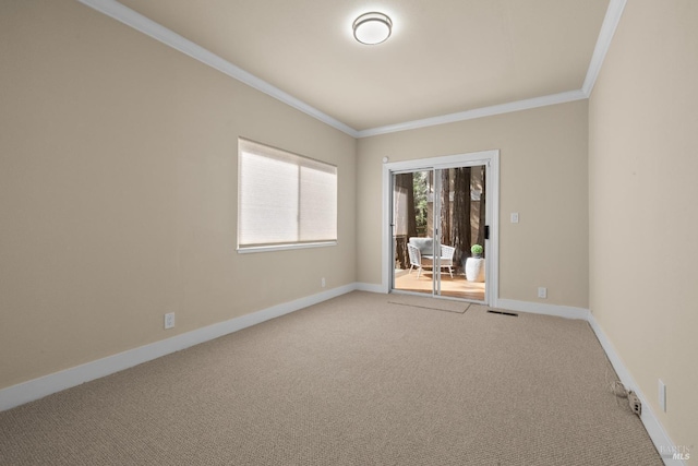 unfurnished room featuring crown molding, carpet, baseboards, and visible vents