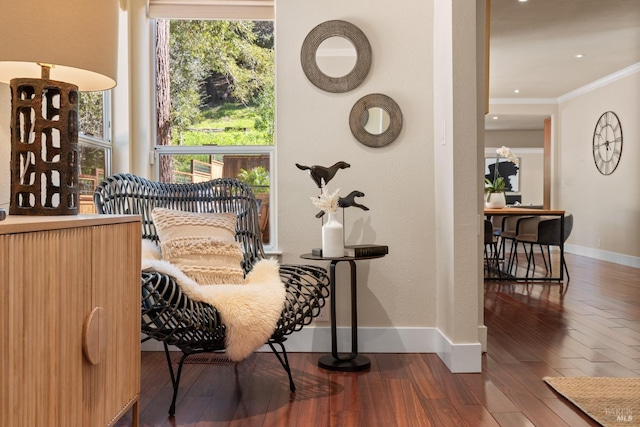 sitting room with crown molding, wood finished floors, and baseboards