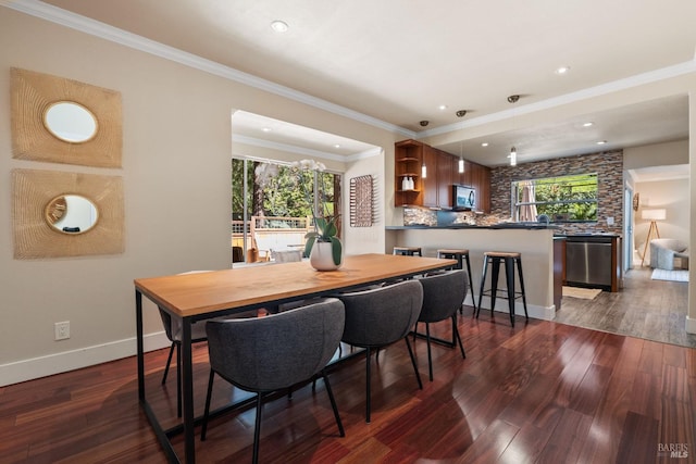 dining area featuring baseboards, a healthy amount of sunlight, dark wood finished floors, and ornamental molding