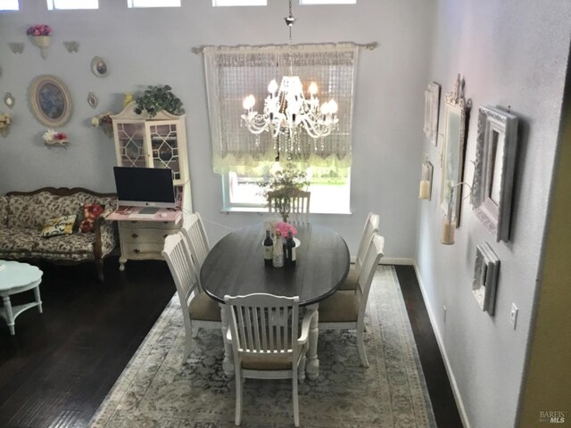 dining room featuring baseboards, wood finished floors, and a chandelier