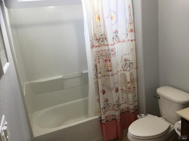 full bathroom featuring shower / bath combination with curtain, toilet, and vanity