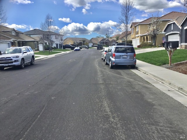 view of street featuring curbs, sidewalks, and a residential view