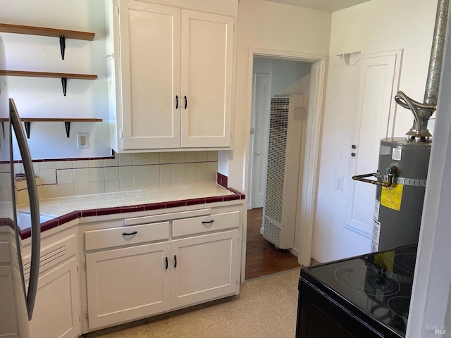 kitchen with secured water heater, black electric range oven, white cabinetry, and open shelves