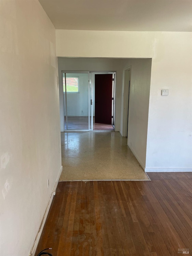 hall featuring baseboards and hardwood / wood-style floors