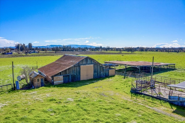 view of outdoor structure featuring an exterior structure, a mountain view, a rural view, and an outdoor structure