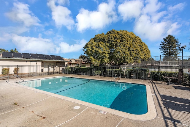 pool with a patio area and fence